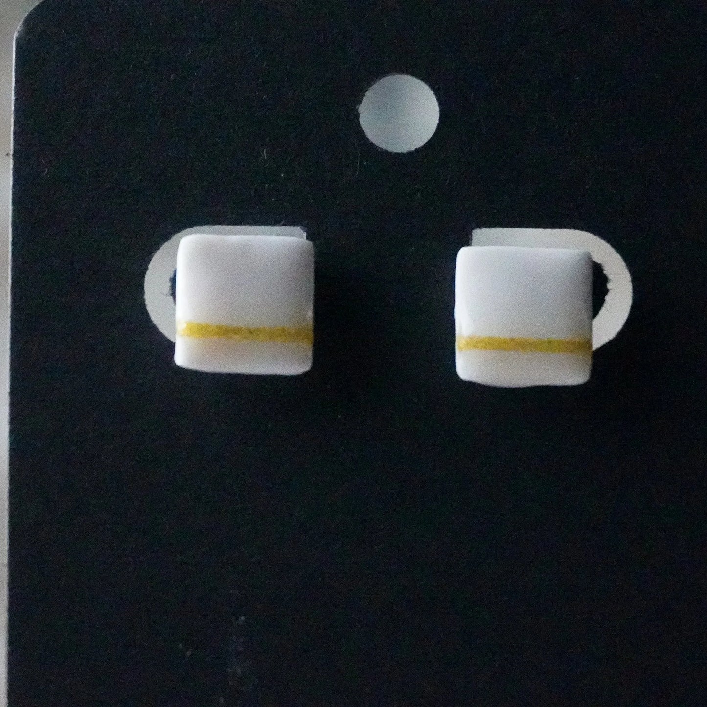 Kleine quadratische Ohrringe (The Line) angesteckt