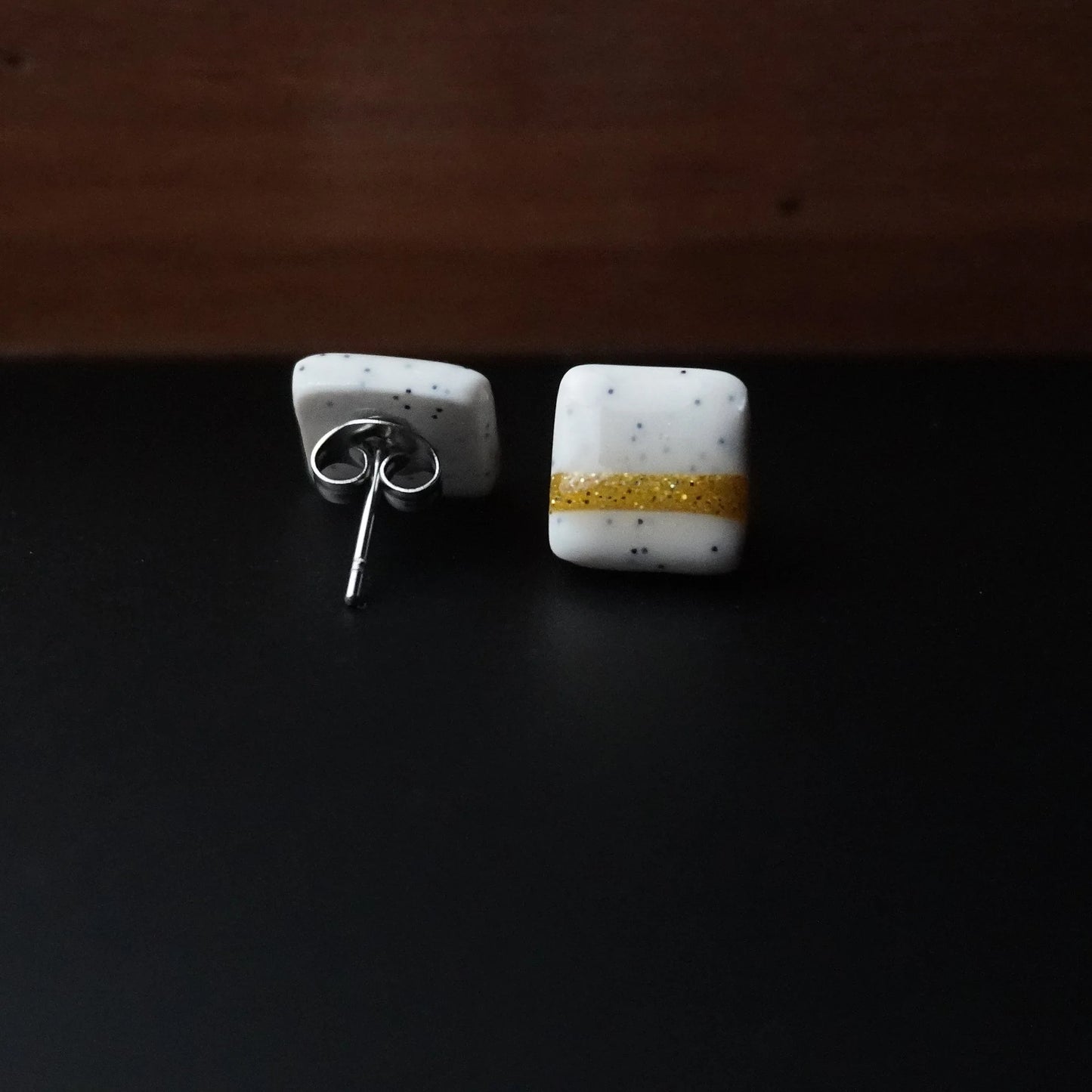 Kleine quadratische Ohrringe (The Line) gepunktet liegend
