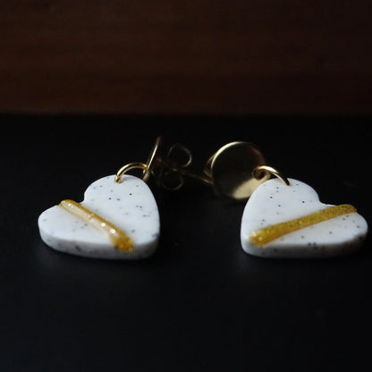 Herz-Ohrringe (The Line) gepunktet goldfarben liegend