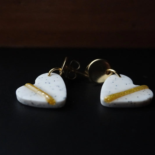 Herz-Ohrringe (The Line) gepunktet goldfarben liegend