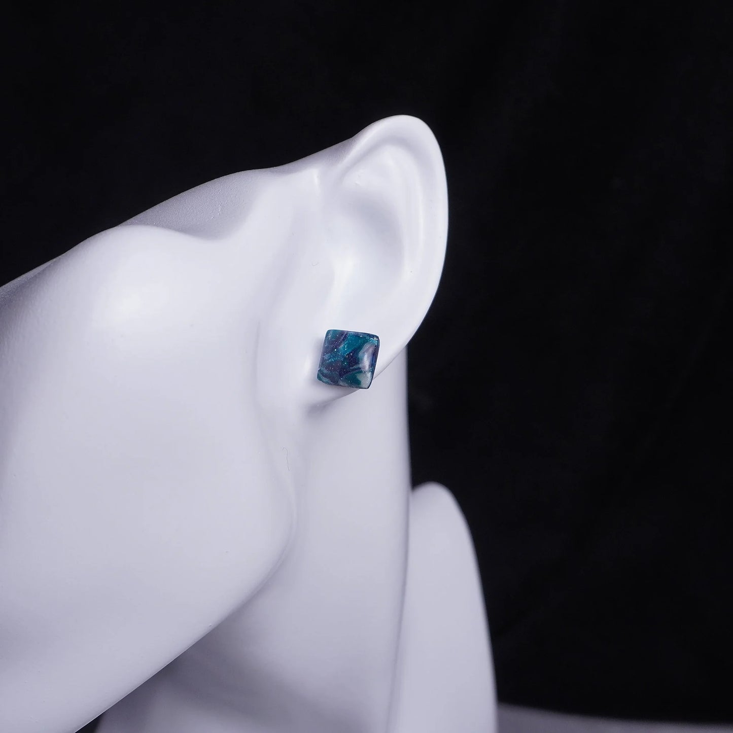 Kleine grünliche quadratische Ohrringe (Galaxy) angesteckt