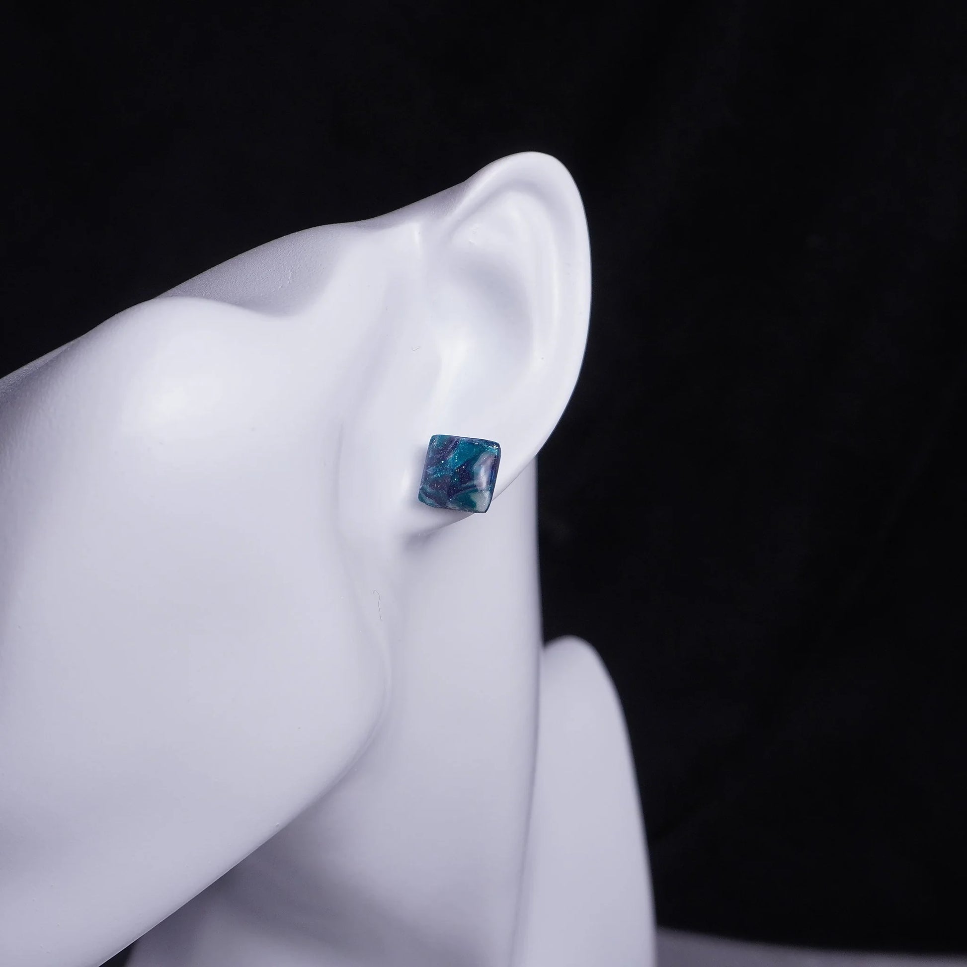 Kleine grünliche quadratische Ohrringe (Galaxy) angesteckt