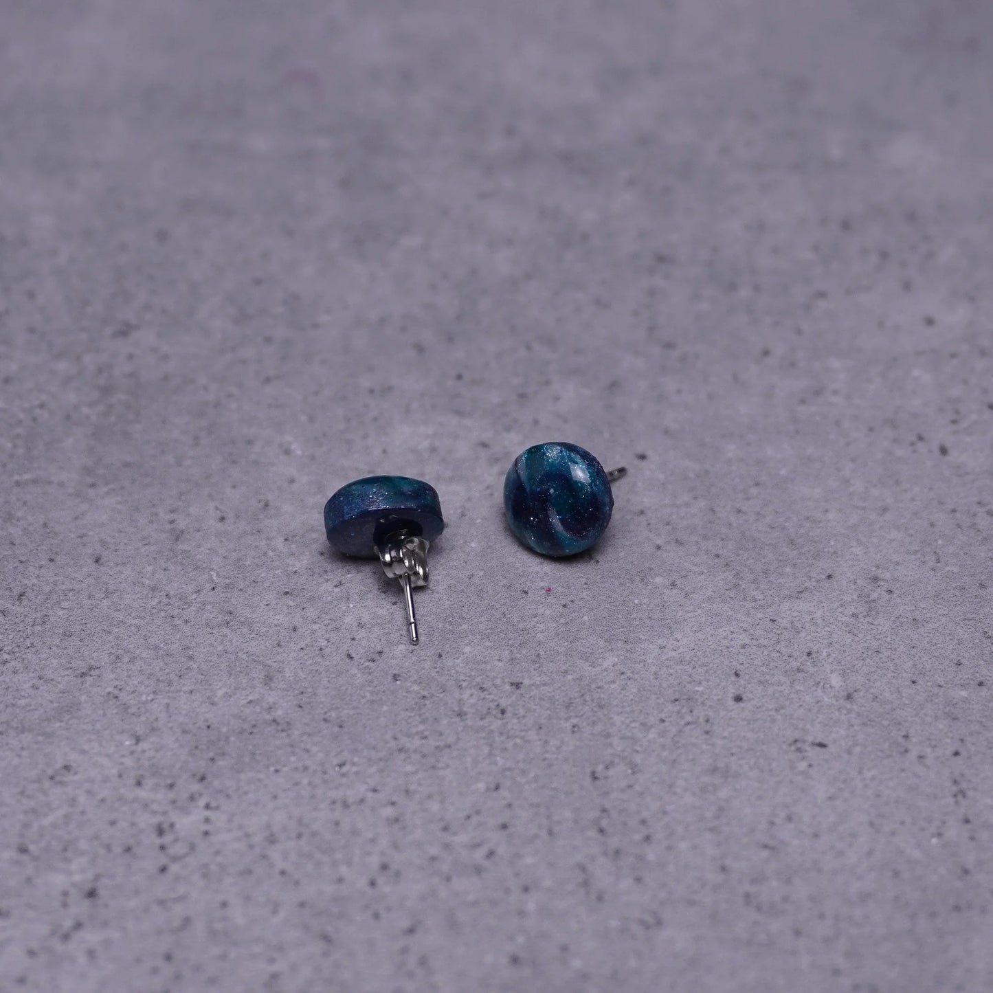 Kleine grünliche runde Ohrringe (Galaxy) liegend