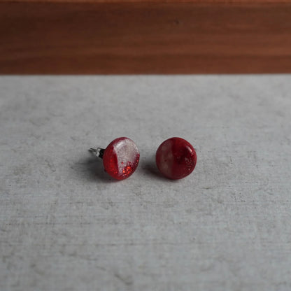 Kleine perlglänzende runde Ohrringe (Red Velvet) liegend