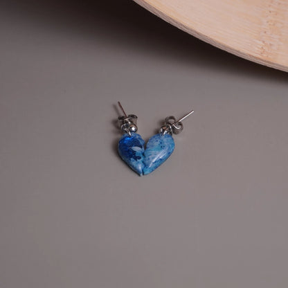 Glitzernde halbe Herz-Ohrringe (Sea Snow) liegend