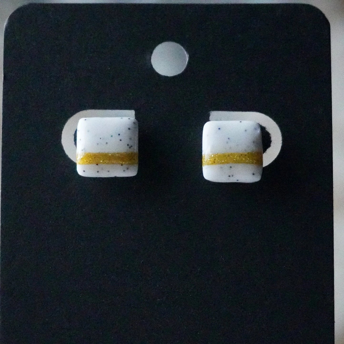 Kleine quadratische Ohrringe (The Line) gepunktet angesteckt
